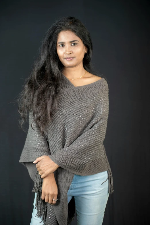 woman posing in grey and silver sweater and jeans