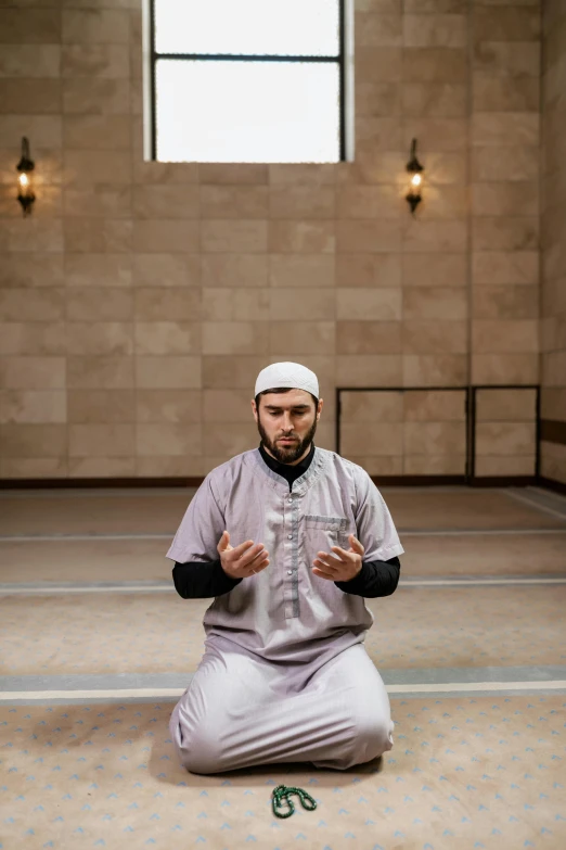 a man in a gray outfit sitting on the ground