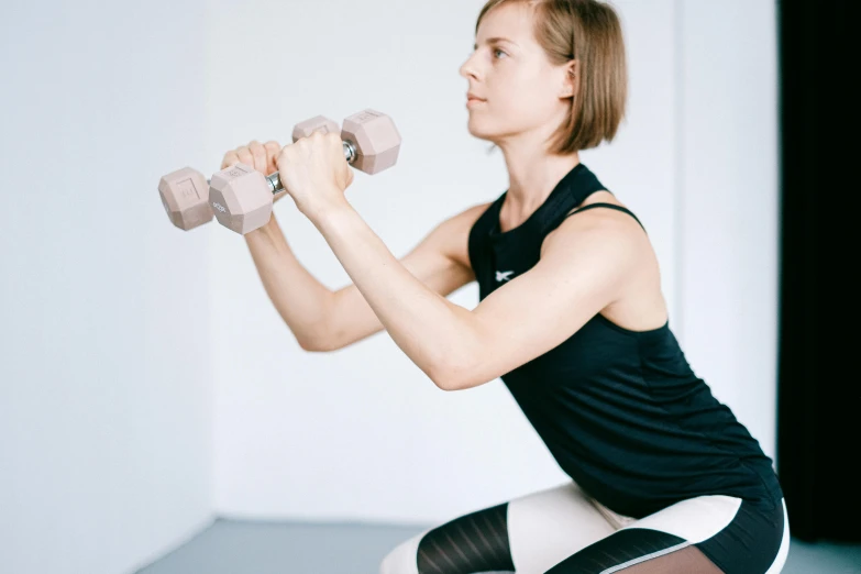 a woman is doing an arm exercise with a dumbbell