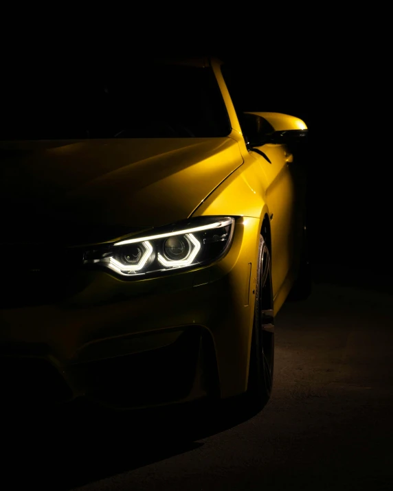 a yellow car at night with its lights turned on