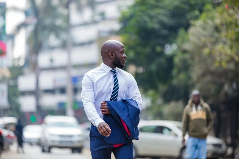 man walking on street with his jacket open and tie pulled back