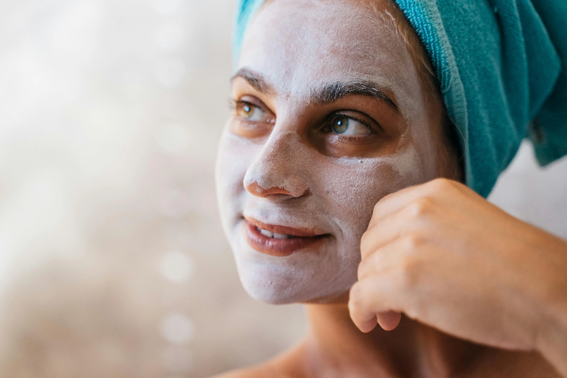 a man in blue and white towels using a facial mask on his face