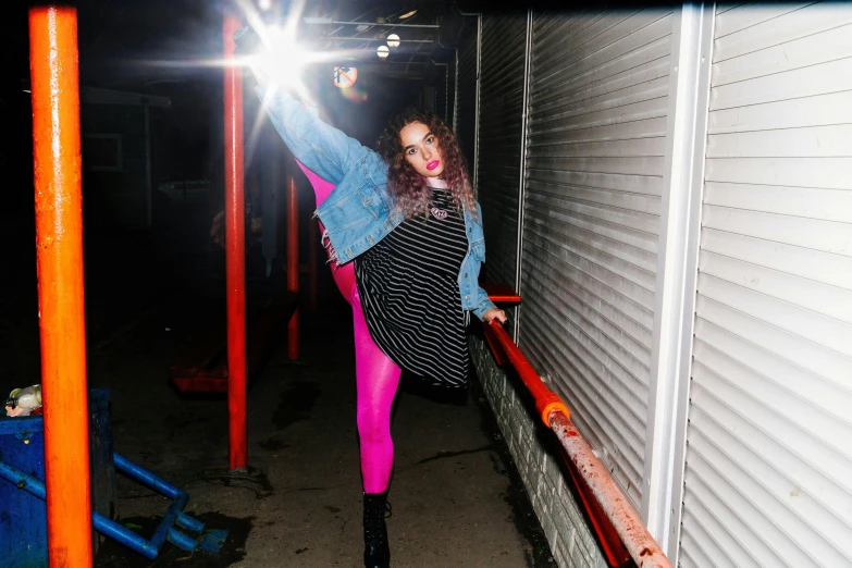 a woman standing in front of a building while wearing a bright colored outfit