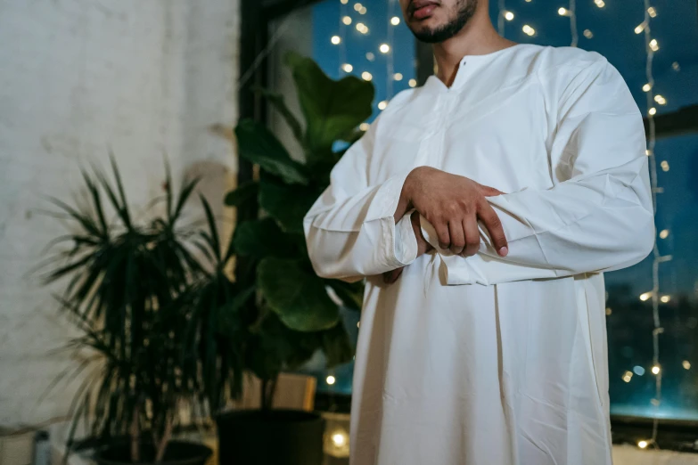 man with dark hair and beard wearing white clothing