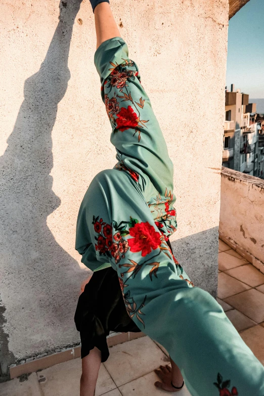 the person with their foot in the air is doing a handstand on a concrete wall