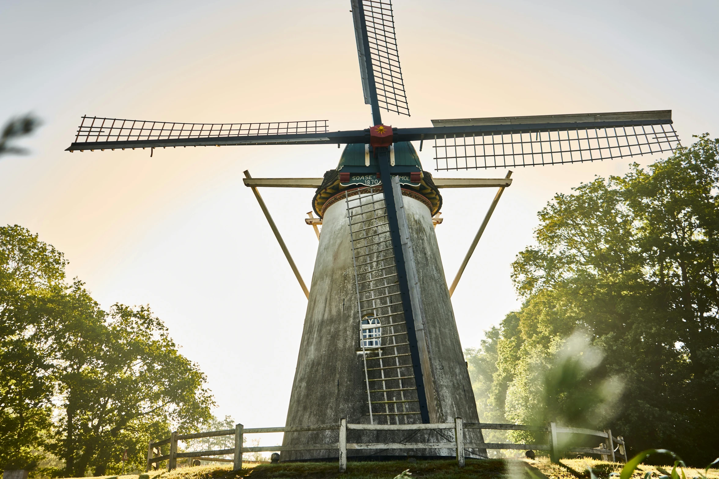 a small windmill is shown near the grass