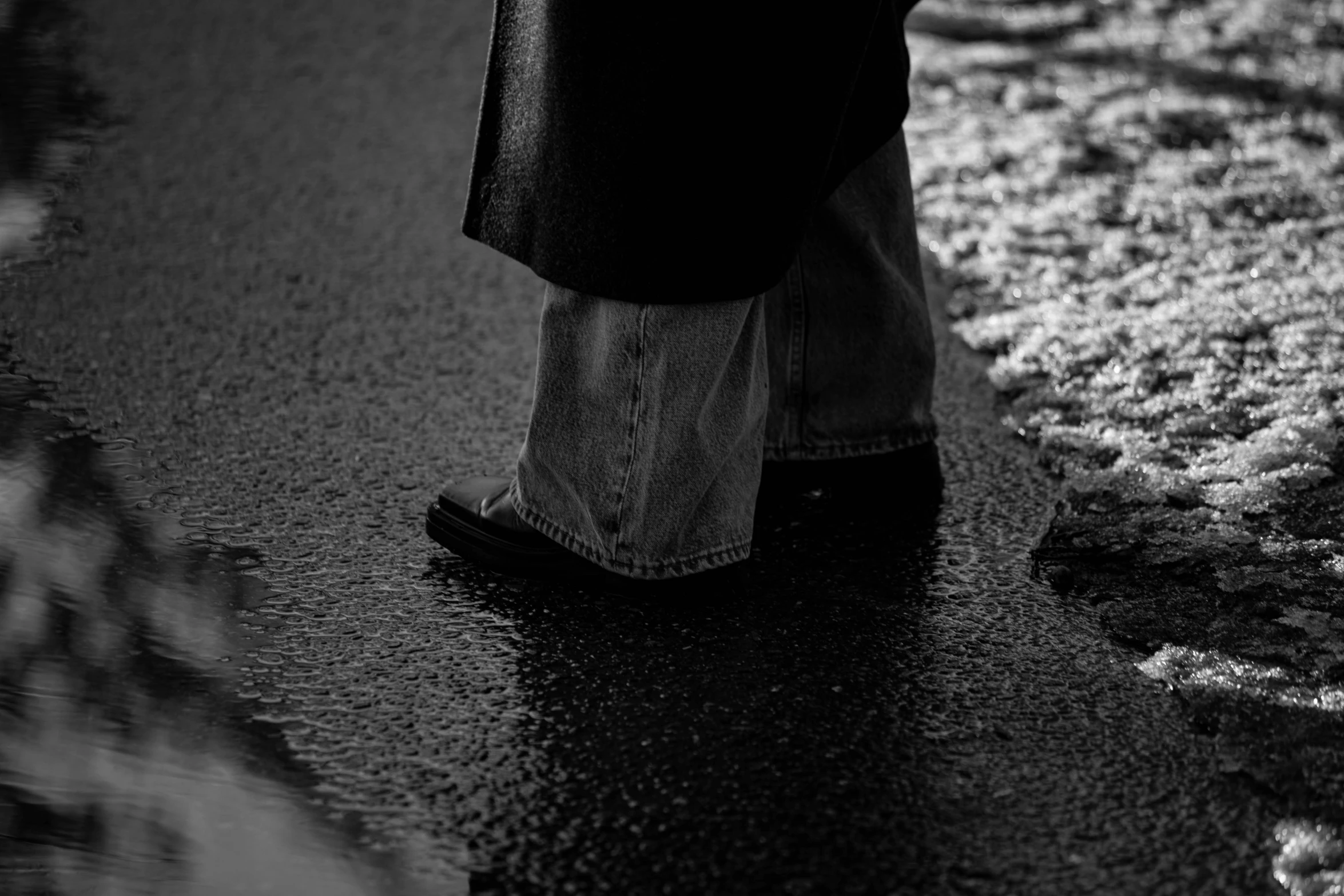 the foot of an individual with black shoes standing in a dle