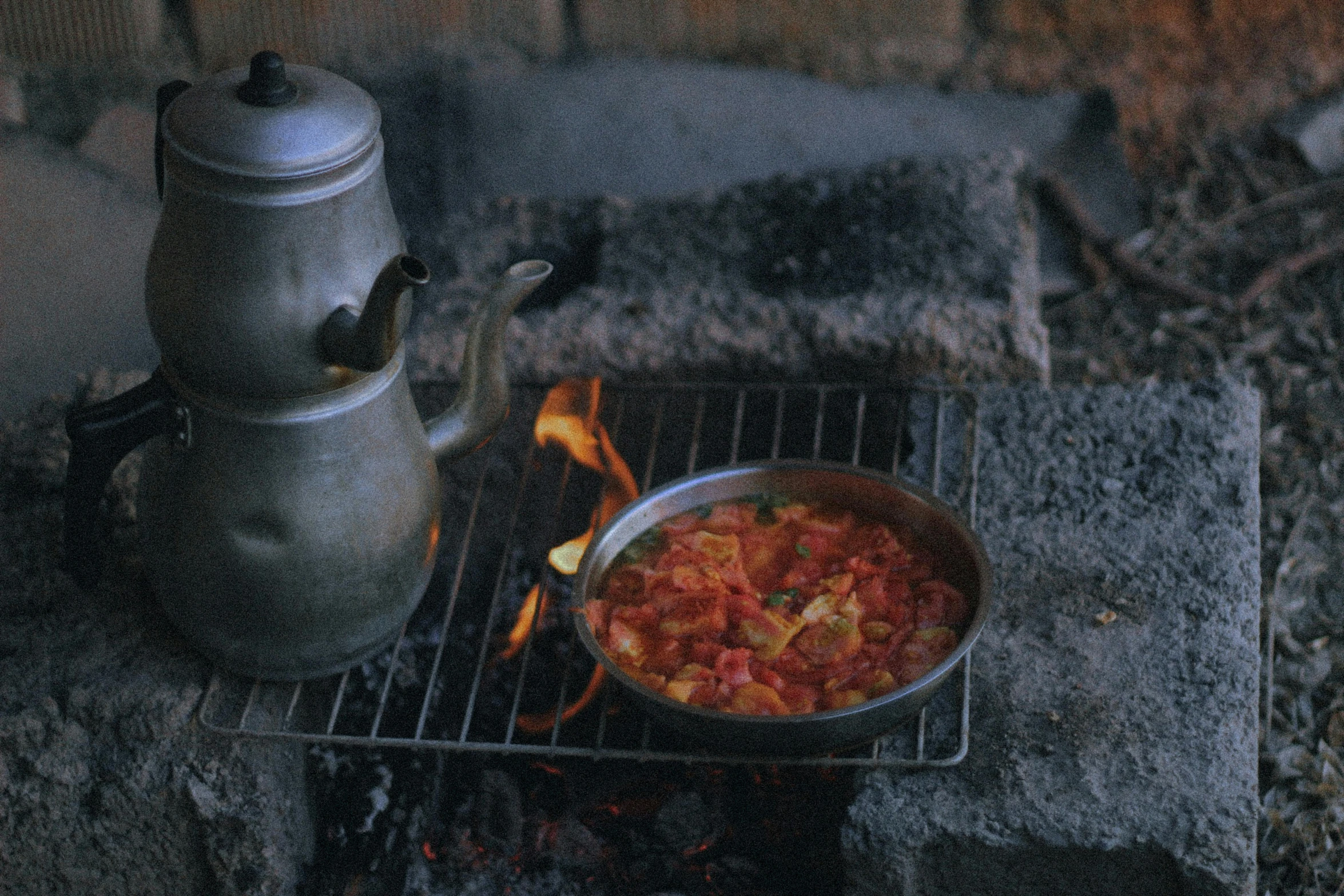 a pan and tea pot on a charcoal grill