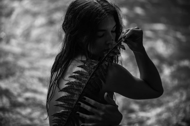 a woman holds a plant near her face