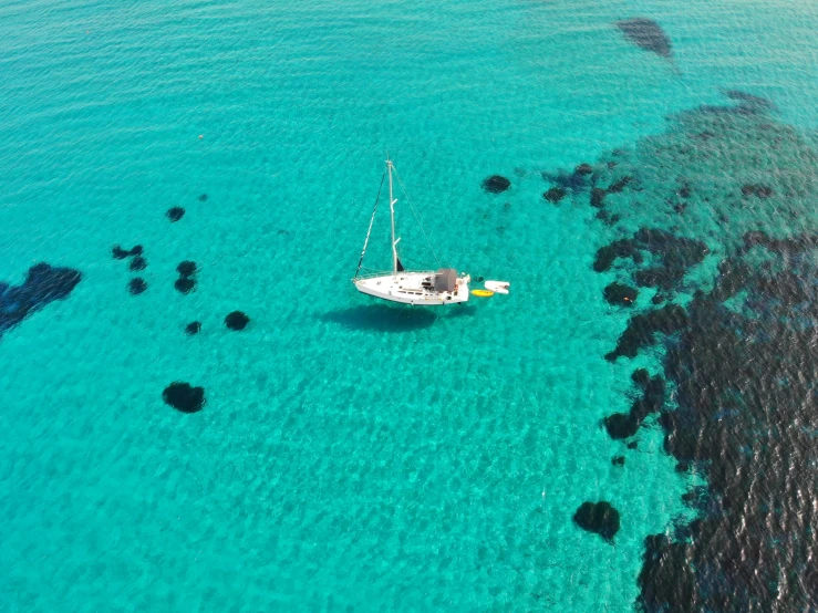 small boat in open blue ocean with corals