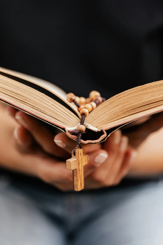 a person holding a book and a rosary