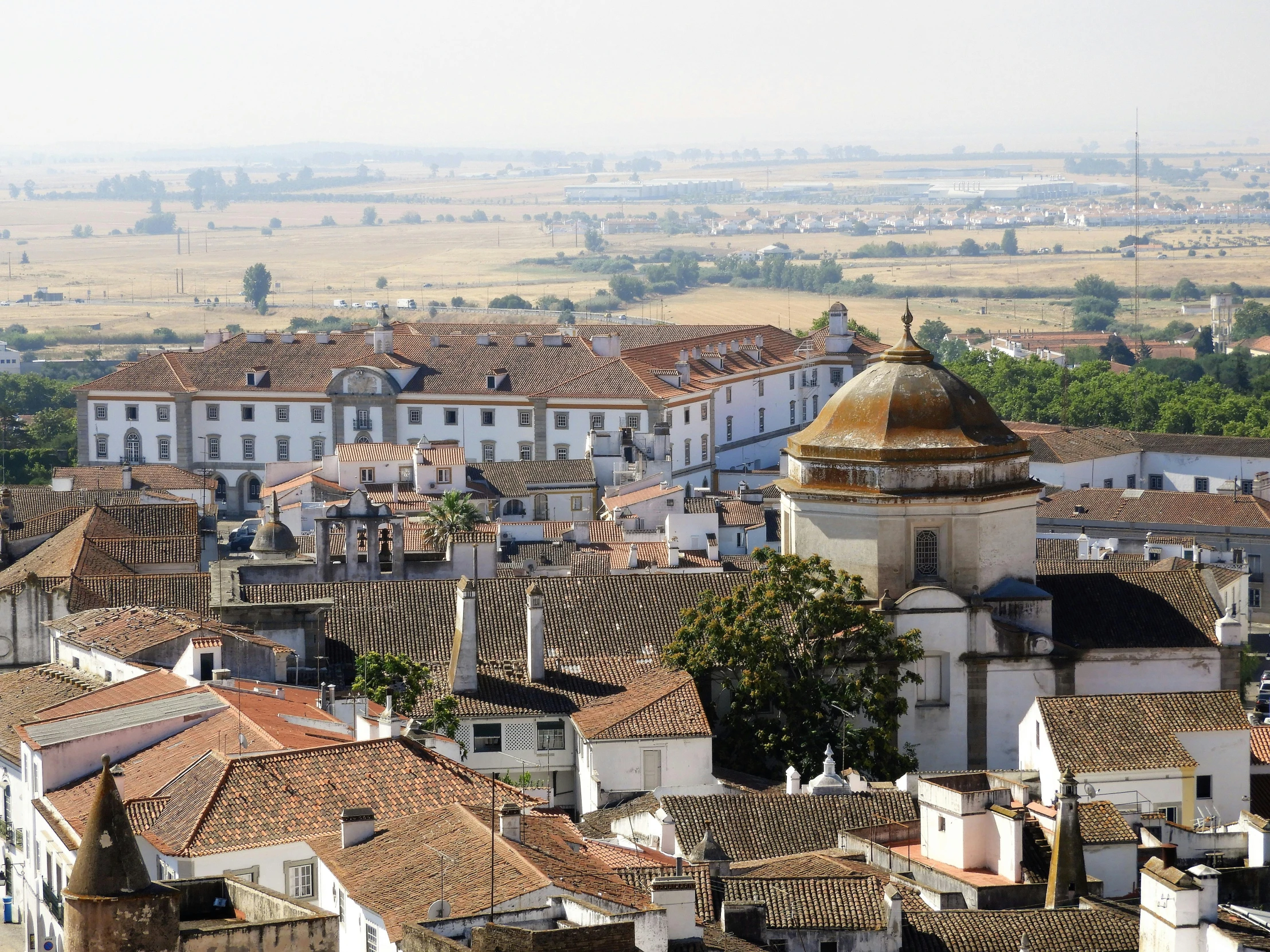 a city with red roof tiles and a clock tower