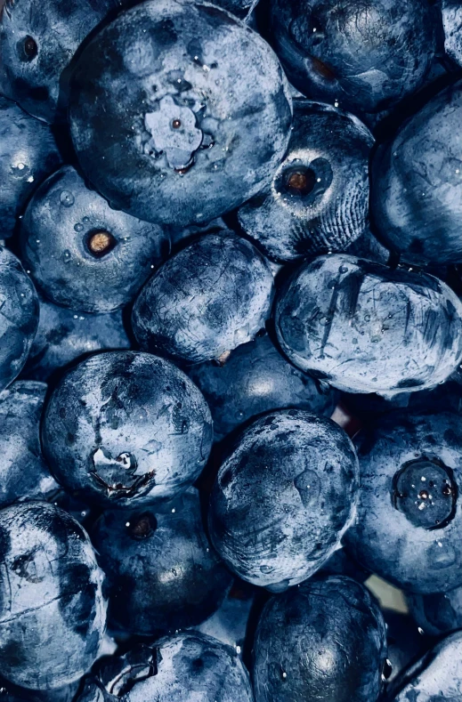 many blueberries are piled together to show dark colors