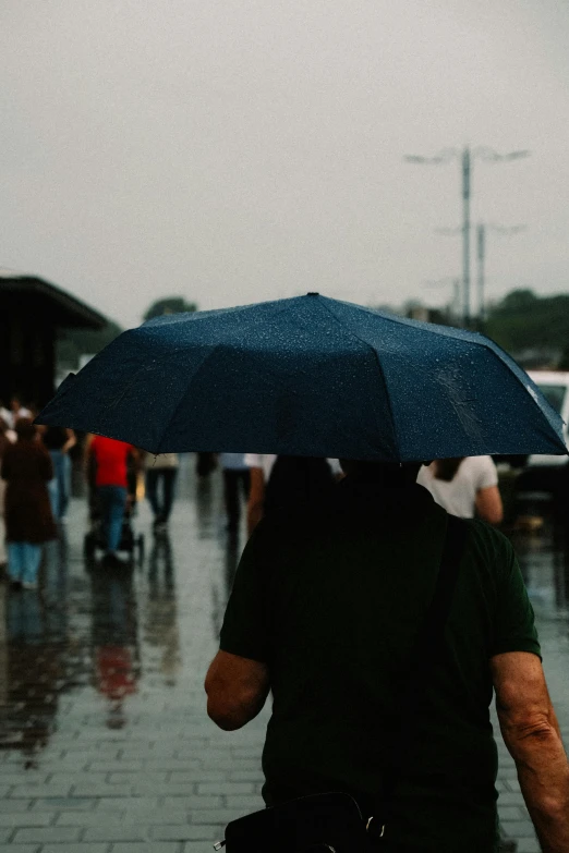 a person holding an umbrella walking down the street on a rainy day