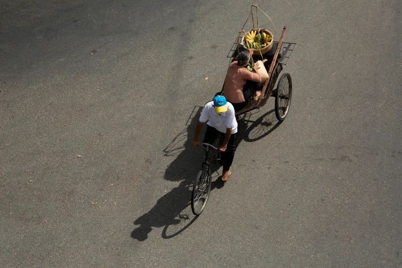 a rickshaw with baskets on its back moving on a road