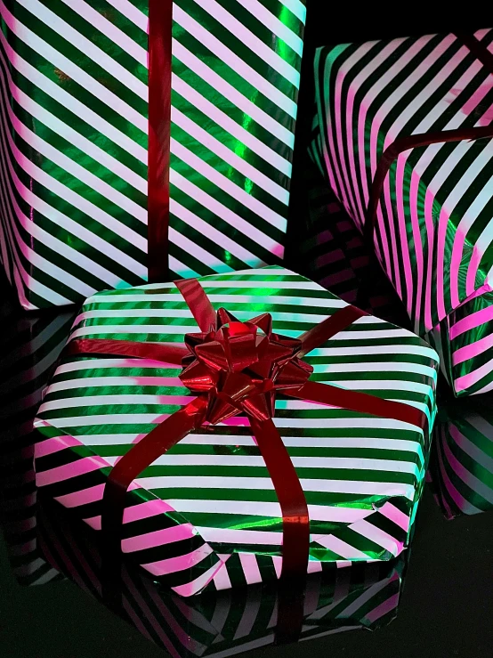 three colorful boxes with lite up bows on them