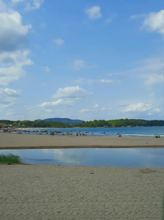 an area with lots of people on the beach and in the water