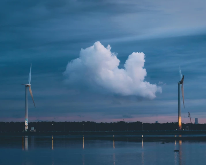 clouds over the water and wind mills in a cloudy sky