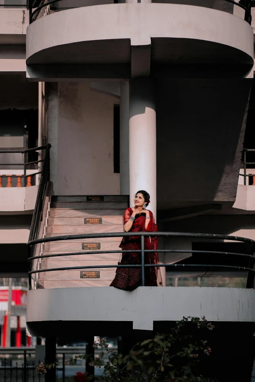 woman standing on balcony talking on phone in urban setting