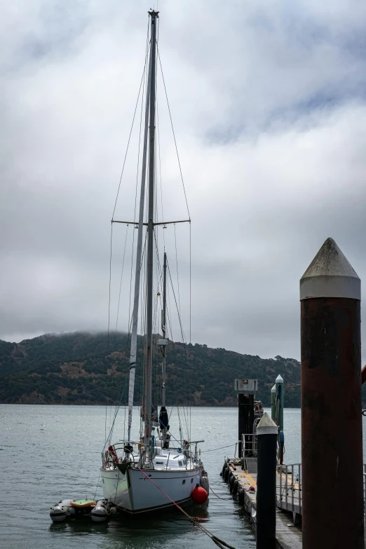 a large white sail boat docked in the water