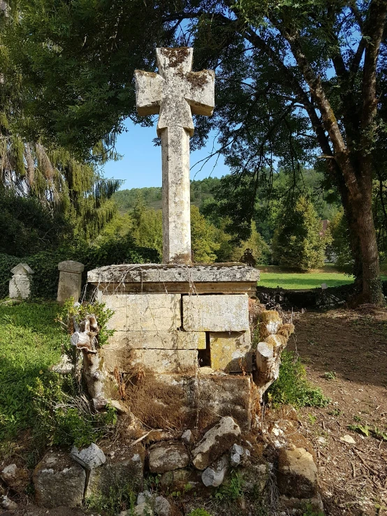 there is a stone cross in the middle of a field