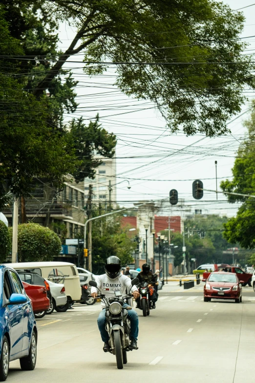 motorcyclists and cars driving on the city street