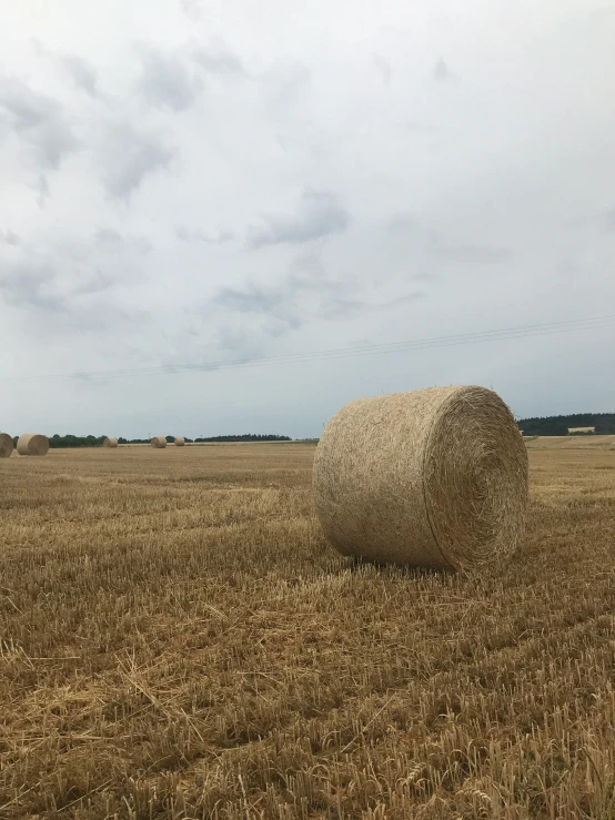 a big round bale of hay is in the middle of a field