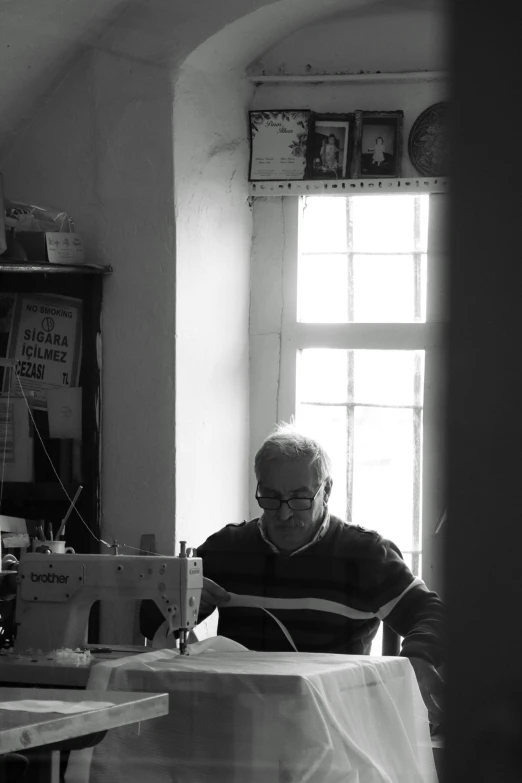 black and white po of an old man using sewing machines
