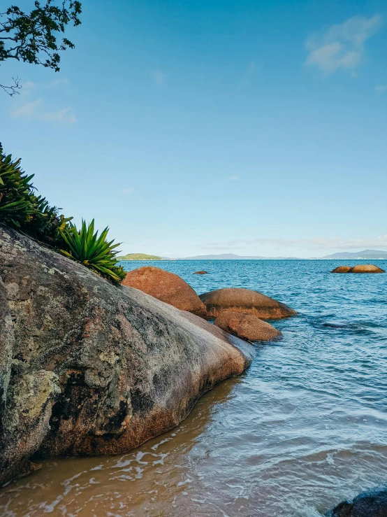 water is running over some rocks into the ocean