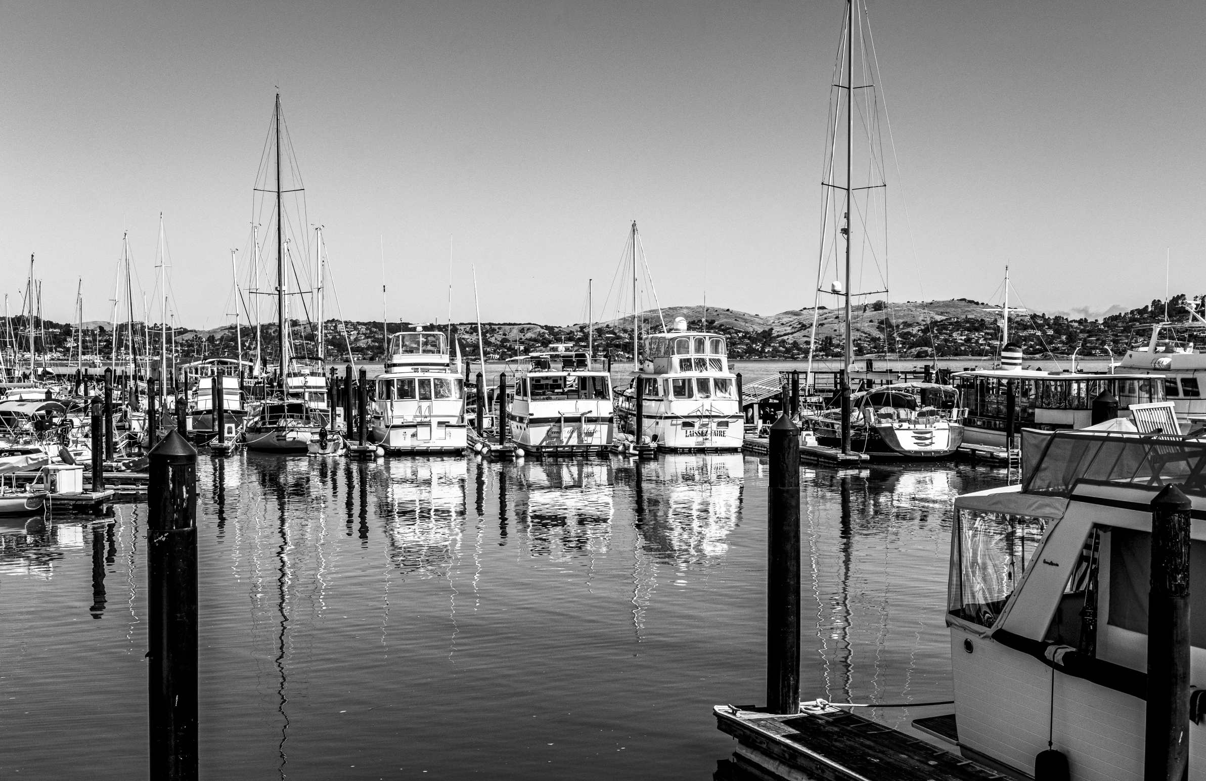 many boats are docked in a harbor on a sunny day