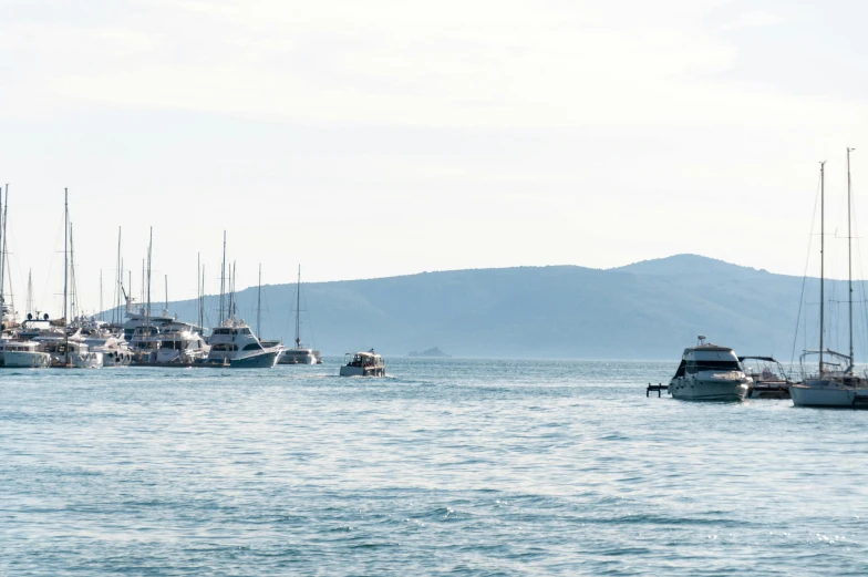 the boats are in the water and the mountains are in the distance