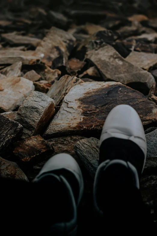 person's feet are seen on a rocky area