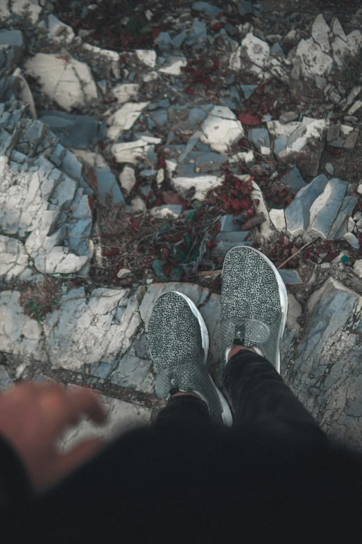 a person wearing sneakers is standing on the ground