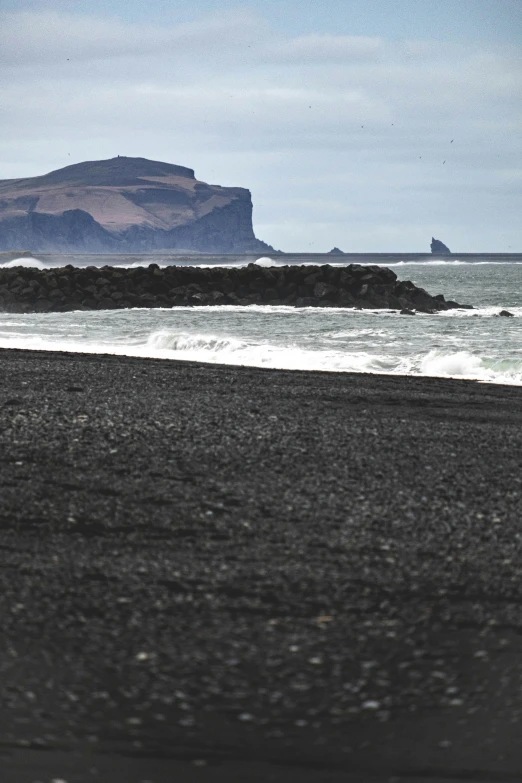 a bird flying by some water and a rock formation