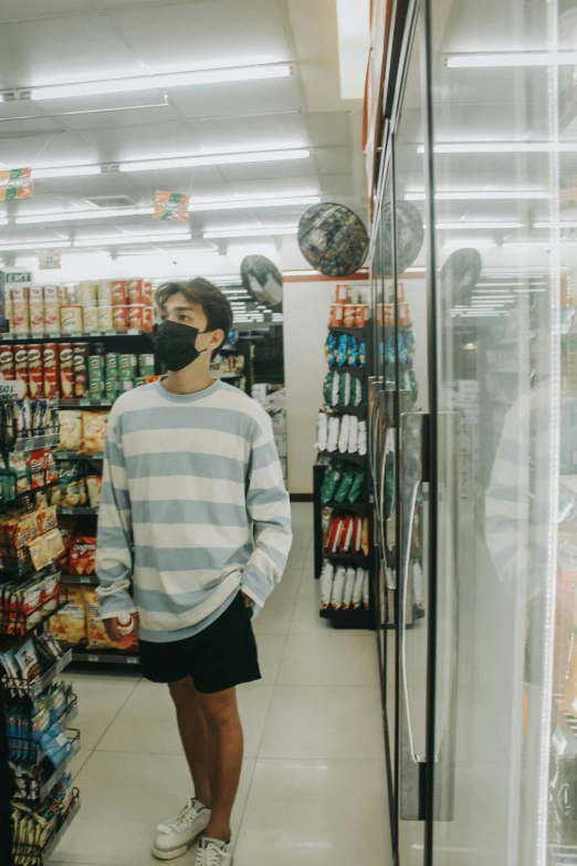 a man wearing a face mask while looking at goods