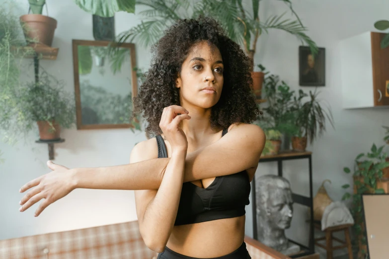 a young woman in a bikini top and shorts is looking up