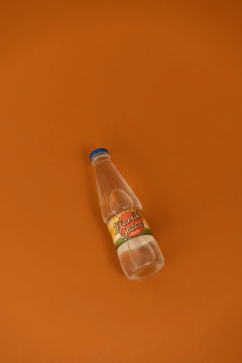 a glass bottle is sitting on an orange surface