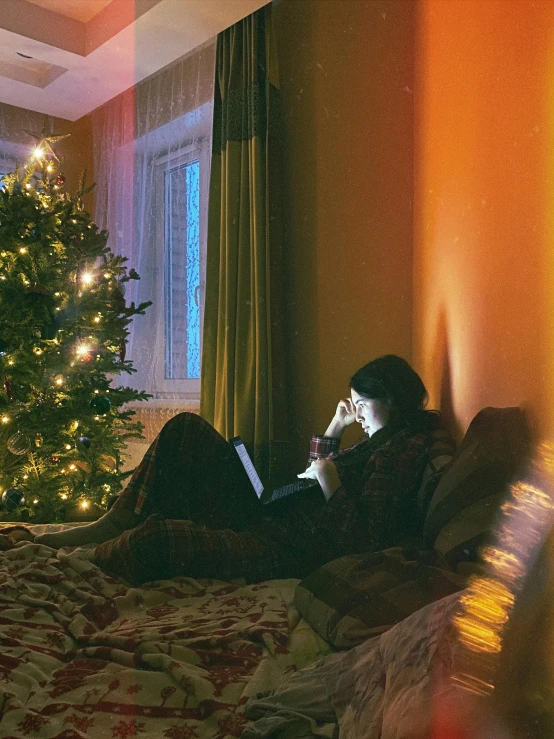 a man with headphones on sitting in bed talking on the phone