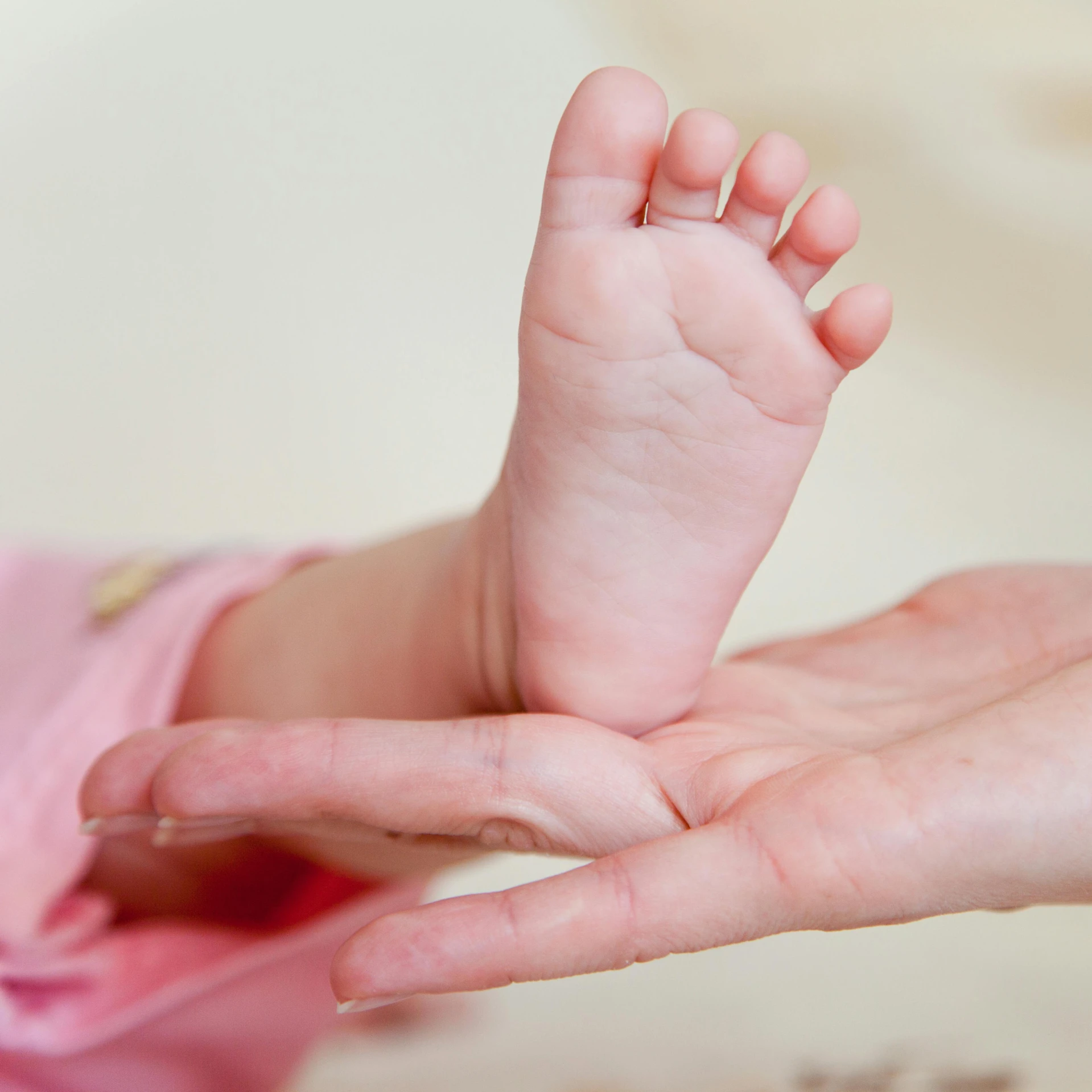 a small baby's foot is sitting in someones palm