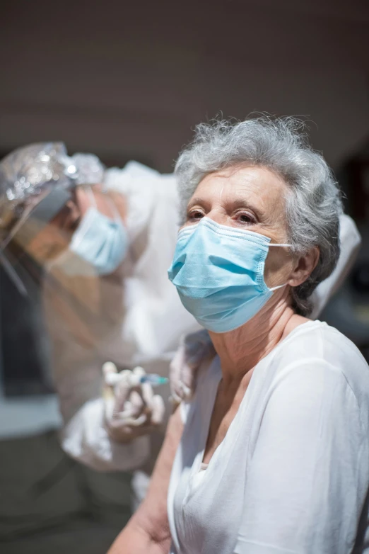 an elderly woman is wearing a surgical mask