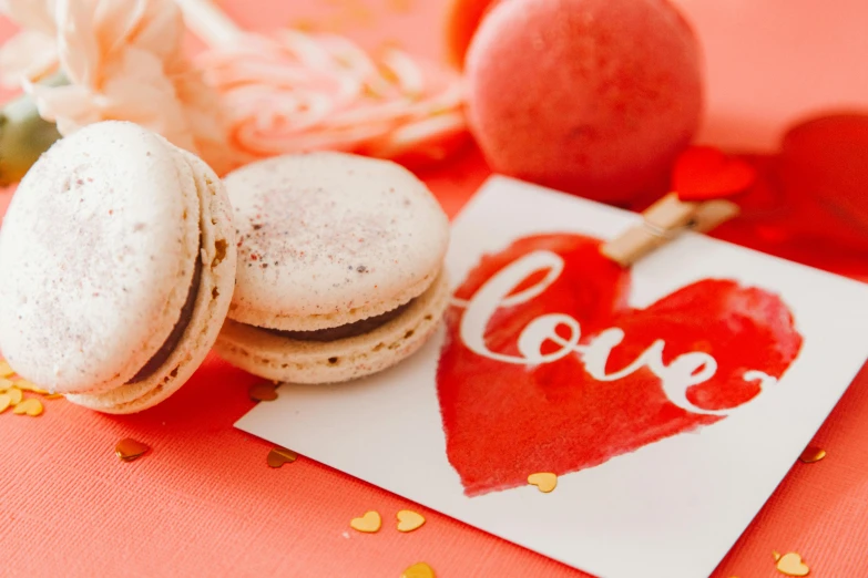 several macaroons are on a pink table