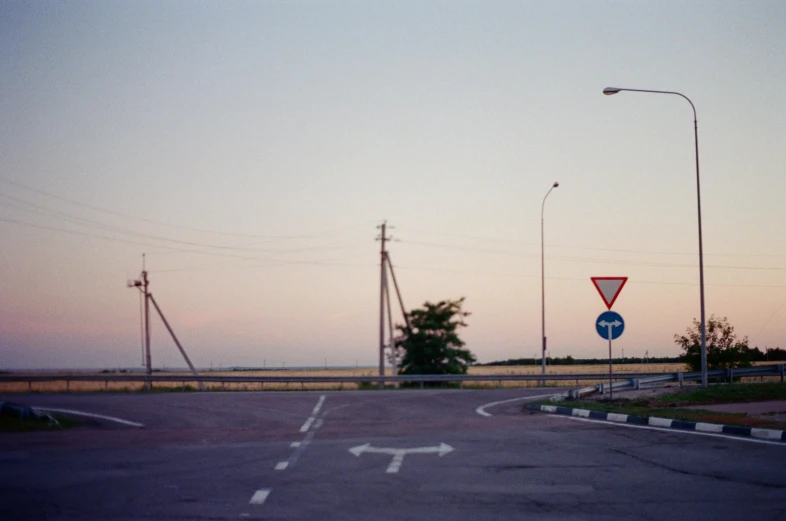 streetlights are pointing in different directions with a road in front