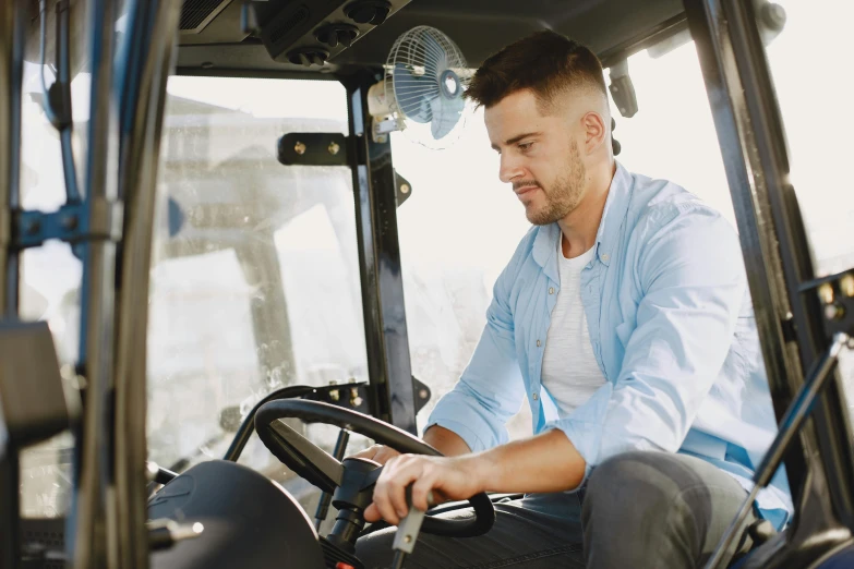 a man in a tractor is holding the steering wheel