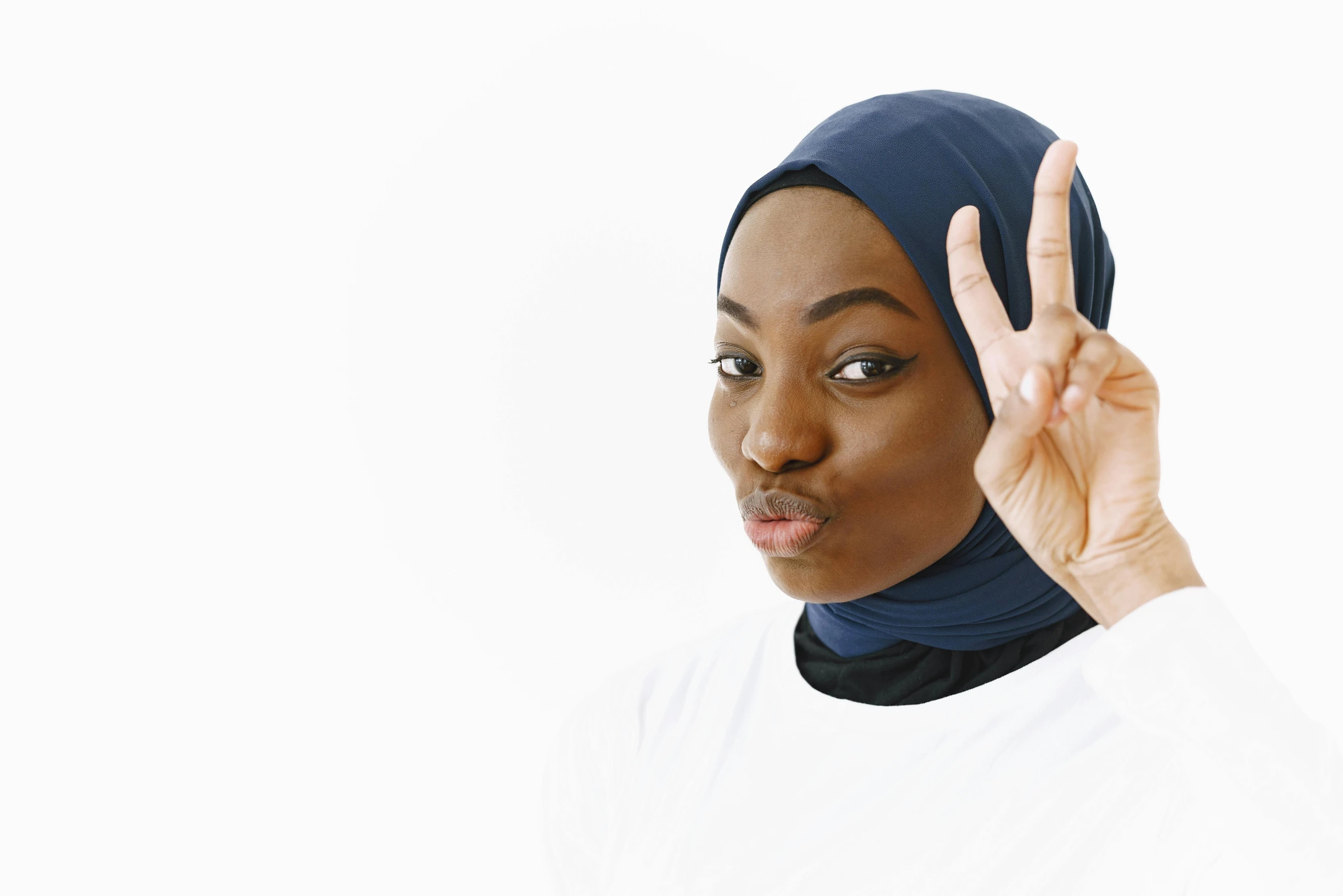 a woman with a turban on making the v sign