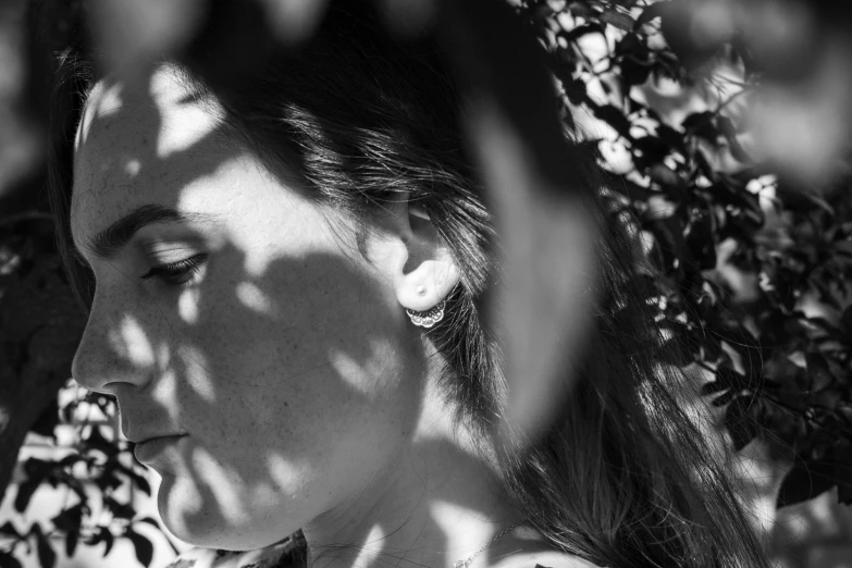 a woman standing near a bush looking out over her shoulder