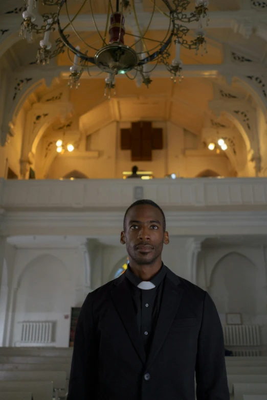 a man standing next to a chandelier inside of a building