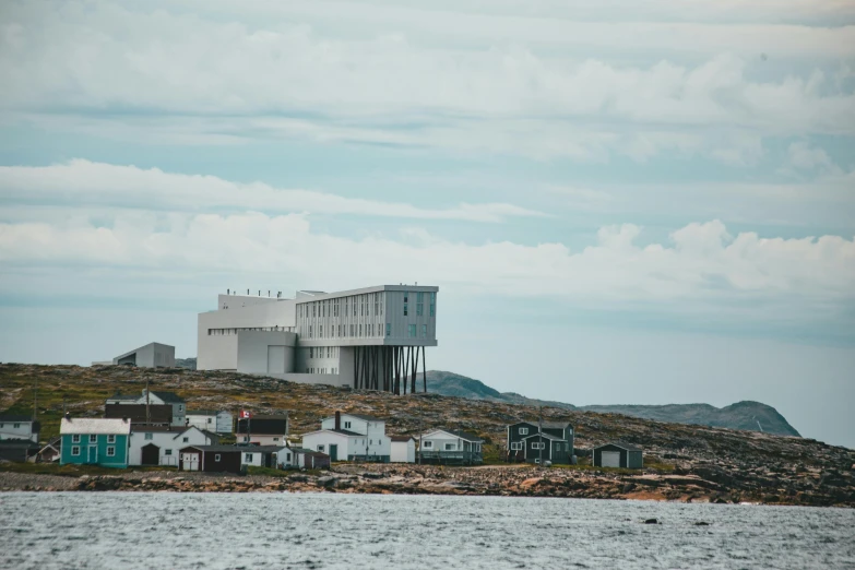 a building sits on top of a hill by the ocean