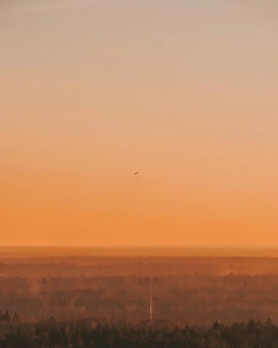 the hazy sky reflects a reddish orange hue as the horizon is shown