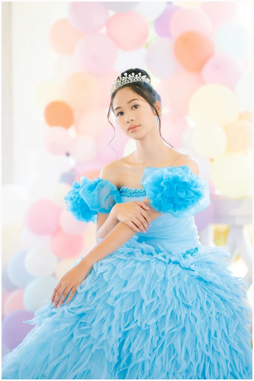 a girl is posing in her pretty blue gown