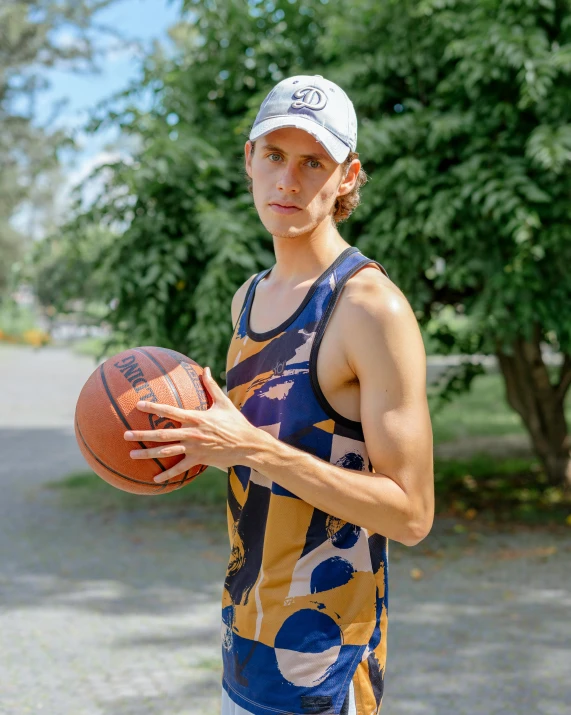 an athletic man holding a basketball on the street